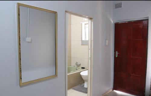 e bagno con specchio, servizi igienici e vasca. di 54 River Logde a Mokopane