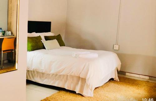 una camera da letto con un grande letto bianco in una stanza di 54 River Logde a Mokopane