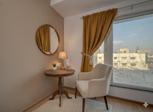 a room with a chair and a table and a window at Hotel Heaven Luxes Opp Miraj Cinemas in Hyderabad