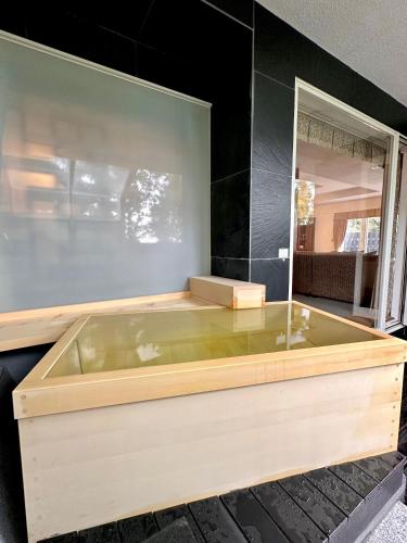 a large wooden bath tub in a room at ISANA Resort in Ito