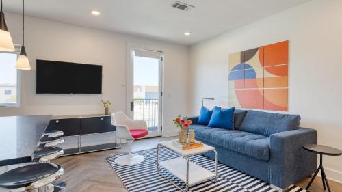 a living room with a blue couch and a tv at The Carter by AvantStay in Nashville