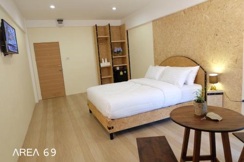 1 dormitorio con cama blanca y mesa en Area 69 (Don Muang Airport), en Bangkok