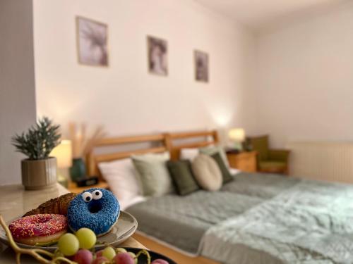 ein Schlafzimmer mit einem Bett und einem Tisch mit einem Teller Essen in der Unterkunft Cottage Apartman Gyula in Gyula