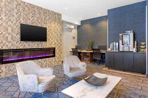 a lobby with two chairs and a tv on a wall at Quality Inn Centre-Ville in Montréal