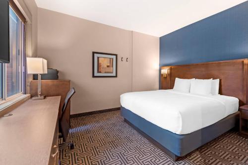 a hotel room with a large bed and a desk at Quality Inn Centre-Ville in Montréal