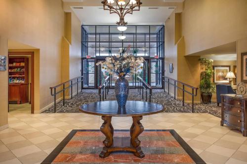 a vase with flowers on a table in a hallway at Clarion Collection Hotel Arlington Court Suites in Arlington