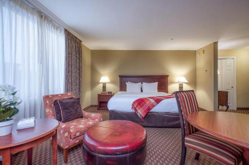 a hotel room with a bed and a table and chairs at Clarion Collection Hotel Arlington Court Suites in Arlington