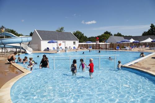 un groupe d'enfants jouant dans une piscine dans l'établissement Domaine Résidentiel de Plein Air Odalys Kerarno, à Saint-Philibert
