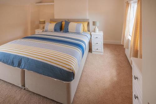 a bedroom with a bed and a dresser and a window at Luxury Town Centre Apartment in Stratford-upon-Avon