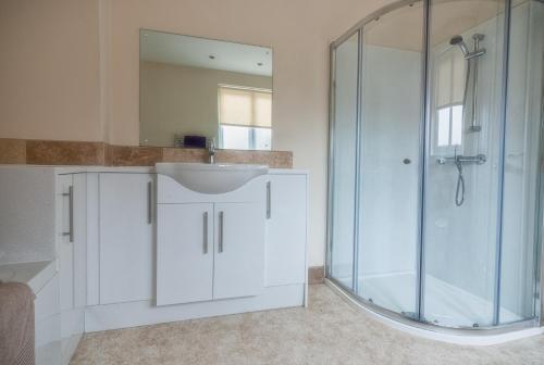 a white bathroom with a sink and a shower at Town Centre Apartment Perfect Location with on-street parking in Stratford-upon-Avon