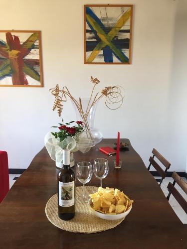 una mesa con una botella de vino y un tazón de patatas fritas en Infinity view, en Vernazza