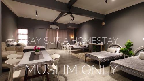 a living room with couches and tables and a sign at KAY'SURIA HOMESTAY in Rawang