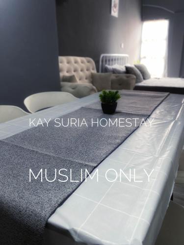 a room with a bed with a table and chairs at KAY'SURIA HOMESTAY in Rawang