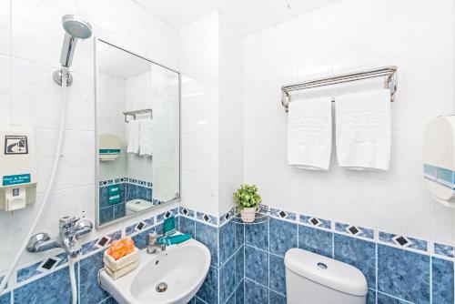 uma casa de banho com um lavatório, um WC e um espelho. em Hotel 81 Cosy em Singapura