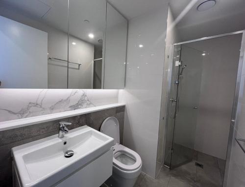 a bathroom with a sink and a toilet and a shower at Where Style Meets Convenience in Melbourne CBD in Melbourne