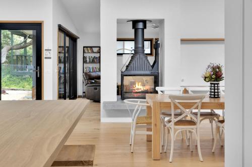 a dining room and living room with a fireplace at Eagle Rock - 400 meters to the beach in Aireys Inlet