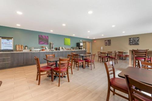 a restaurant with tables and chairs and a bar at Sleep Inn & Suites Wisconsin Dells - Lake Delton in Wisconsin Dells