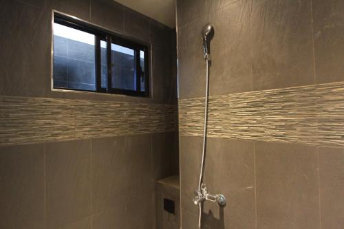 a shower stall in a bathroom with a window at Hido Hostel III in Kenting