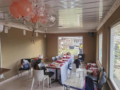 a dining room with a table and chairs and balloons at Phiris B&B in Esperanza