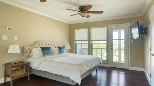 レイクウェイにあるTravis by AvantStay Waterfront Lake Retreatのベッドルーム1室(ベッド1台、シーリングファン付)