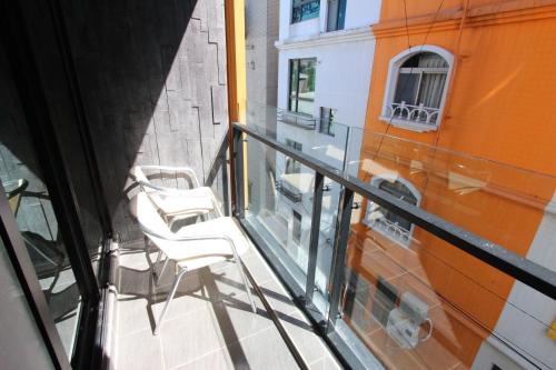Hido Hostel III في كنتيج: شرفة بها كرسيان أبيضان في مبنى