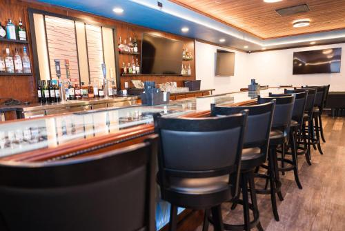 a bar with a row of chairs in a restaurant at Chateau Hotel and Conference Center in Bloomington
