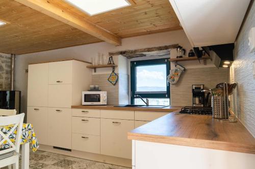 a kitchen with white cabinets and a window at Casa Rosa Tradizionale in Roccascalegna