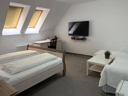 a bedroom with two beds and a flat screen tv at Saint Michael - Garni Hotel in Trnava