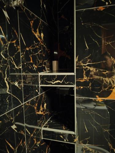 a bathroom with a marble wall with a mirror at Modern central apartment in Serres