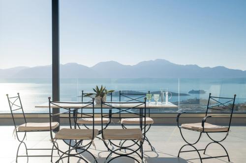 a table and chairs with a view of the ocean at Horizon View Villa in Agios Nikolaos