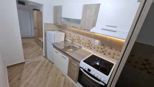 a small kitchen with a sink and a stove at Stan na dan Apartman in Bor
