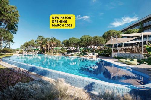 a pool at a resort with a yellow sign that reads new resort opening march at Pical Resort, Valamar Collection in Poreč