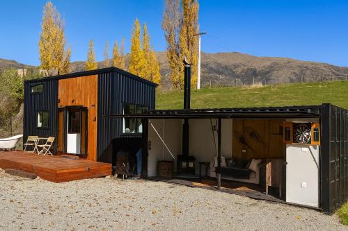 a black house with a porch and a patio at Grace & Rose in Gibbston