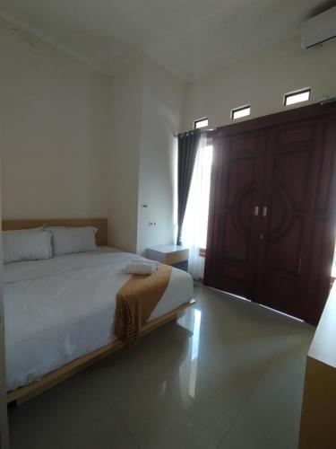 a bedroom with a large bed and a window at Mutu Edutel in Panggungrejo