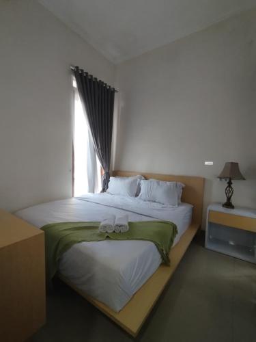 a bedroom with a large bed with towels on it at Mutu Edutel in Panggungrejo