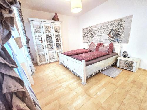 a bedroom with a bed with red pillows on it at Kunstapartment mit 2 Schlafzimmer Max 4 Personen in Spitz