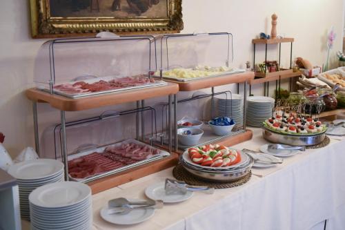 - un buffet avec des assiettes et de la nourriture sur une table dans l'établissement Hotel Villa Erica, à Grado