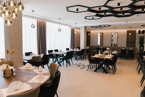a dining room with tables and chairs and chandeliers at Hotel Karting in Mostar