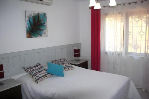 Una cama blanca con dos almohadas encima. en Villa Celeste, en Velilla