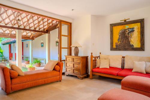 a living room with two orange chairs and a painting at Villa Inavni in Talawatugoda