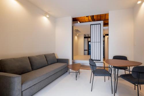 a living room with a couch and a table and chairs at Miharaya in Onomichi
