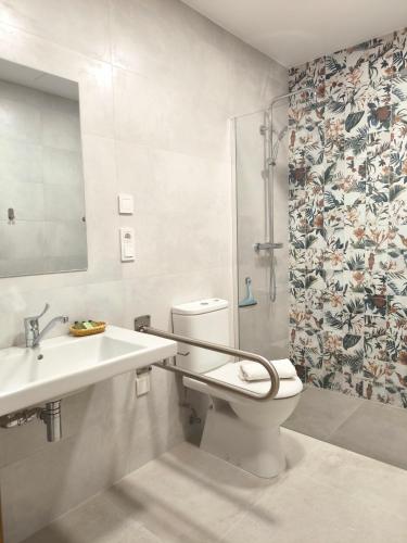 a bathroom with a toilet and a sink and a shower at El Jazmín del Patio in Nerja