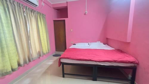 a pink room with a bed with a pink wall at EV7 Stays in Trichūr