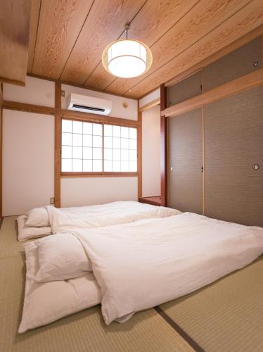 a large white bed in a room with a window at 大戸別邸 Oto Villa 小江戸佐原や鹿島香取神宮観光にも便利な一棟貸しの宿 in Katori