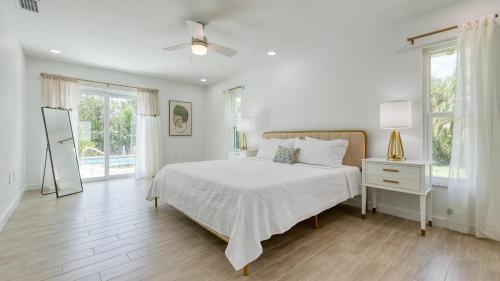 ein weißes Schlafzimmer mit einem Bett und einem Fenster in der Unterkunft Casa Bonita by AvantStay Large Backyard Patio Pool Hot Tub in Bonita Springs