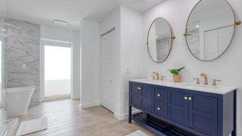 ein Badezimmer mit einem blauen Waschtisch und einem Spiegel in der Unterkunft Casa Bonita by AvantStay Large Backyard Patio Pool Hot Tub in Bonita Springs