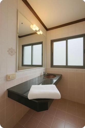 a bathroom with a sink and a mirror at Omalaya Bangkok in Samphanthawong