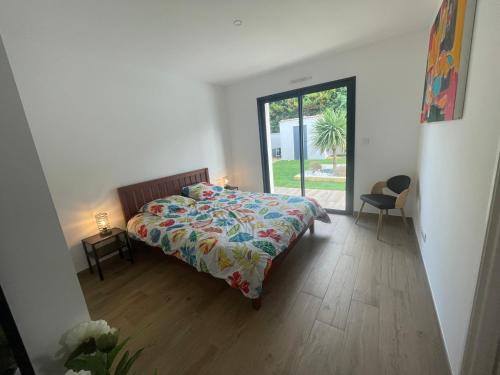 a bedroom with a bed with a colorful comforter at maison la rochelle 3 étoiles in Marsilly