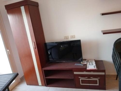 een woonkamer met een tv en een houten entertainmentcentrum bij شاليه مرسى علم in Marsa Alam