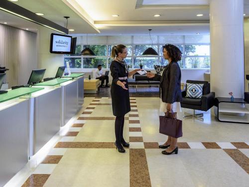 two women standing in a lobby talking at Mercure Sao Paulo Jardins in Sao Paulo